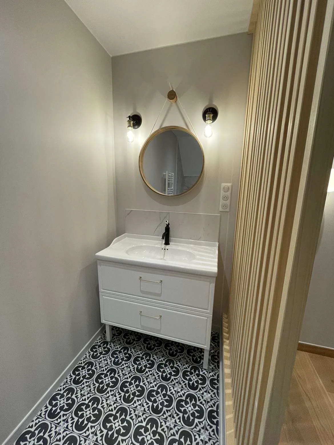 Salle de bain rénovée — vasque, miroir rond, mur gris, carreaux ciment, Seine-et-Marne